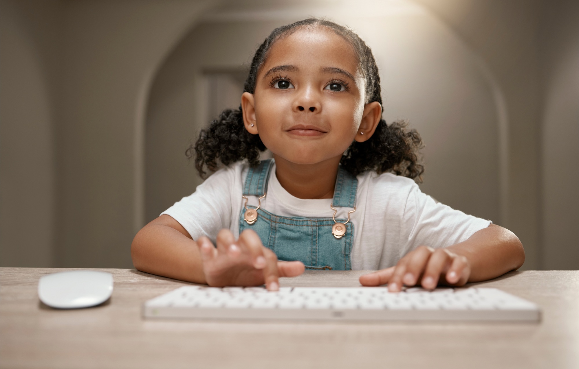 Child, internet and keyboard with a little girl browsing online to learn and gain knowledge or educ