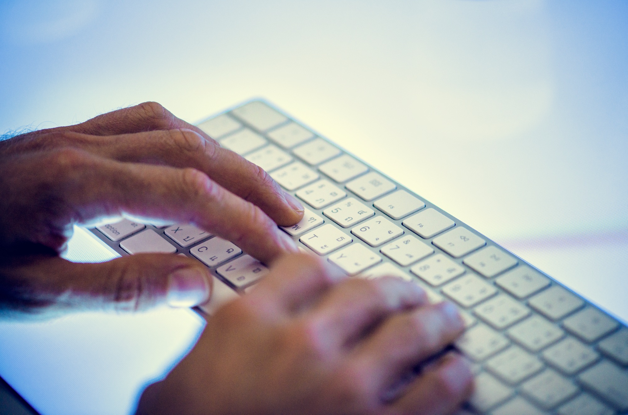 Hands typing on a keyboard