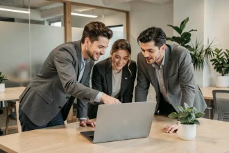 Équipe de professionnels collaborant autour d'un ordinateur portable pour organiser des envois de fichiers en entreprise